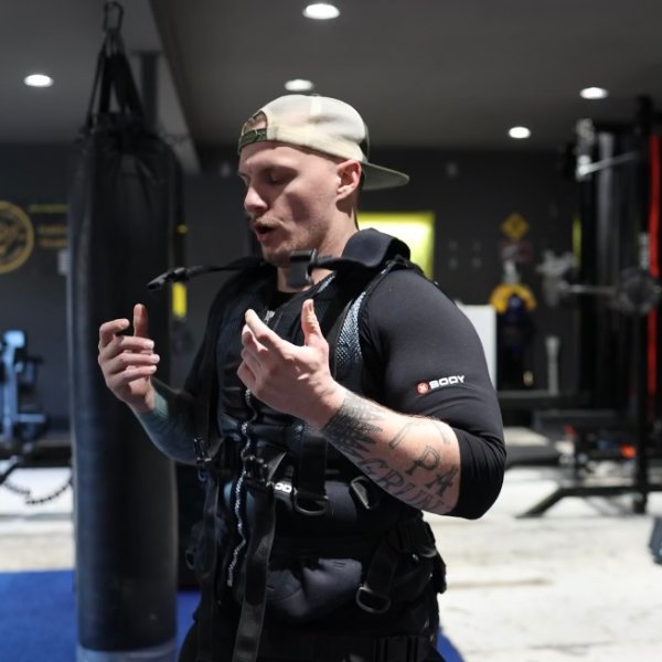 Coach Dave wearing the XBody EMS suit beside the heavy bag