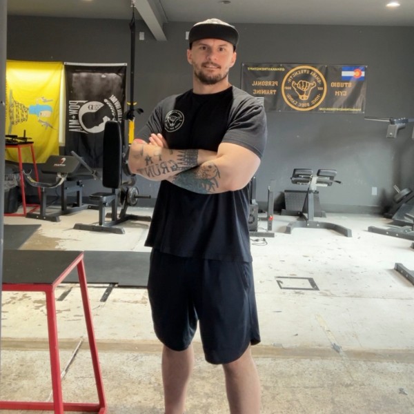 Coach Dave Luketic, arms crossed, in the Shaka Strength Fitness studio