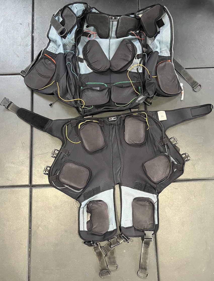 The XBody EMS training suit laid out flat, showing the electrode pads on the vest, arms and legs